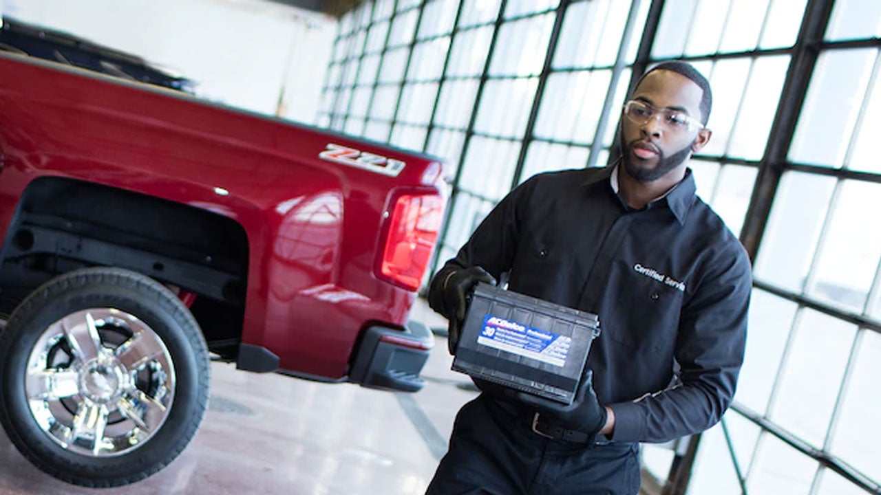 technician holding a car battery
